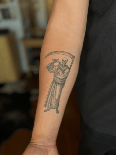A black and grey linework tattoo of a skeleton holding a scythe on the forearm, featuring detailed shading and fine lines — by Dylan Aiello, los angeles