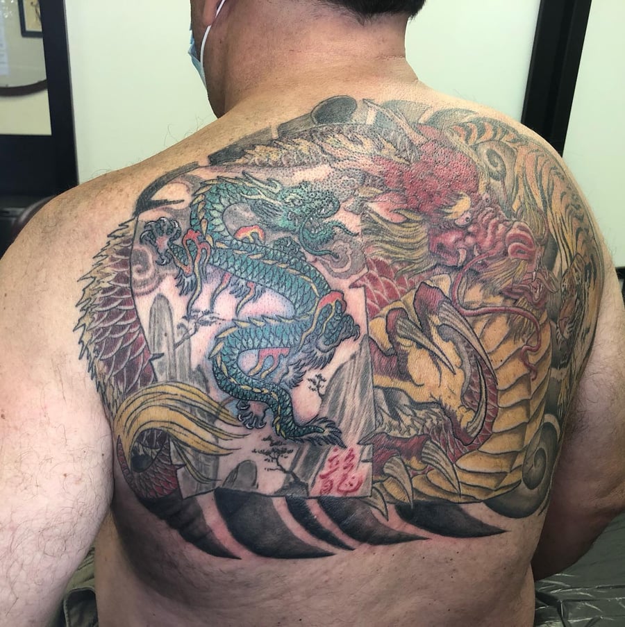A colorful Japanese-style dragon tattoo covering the back with intricate details and bold colors — by Sandra Price, los angeles
