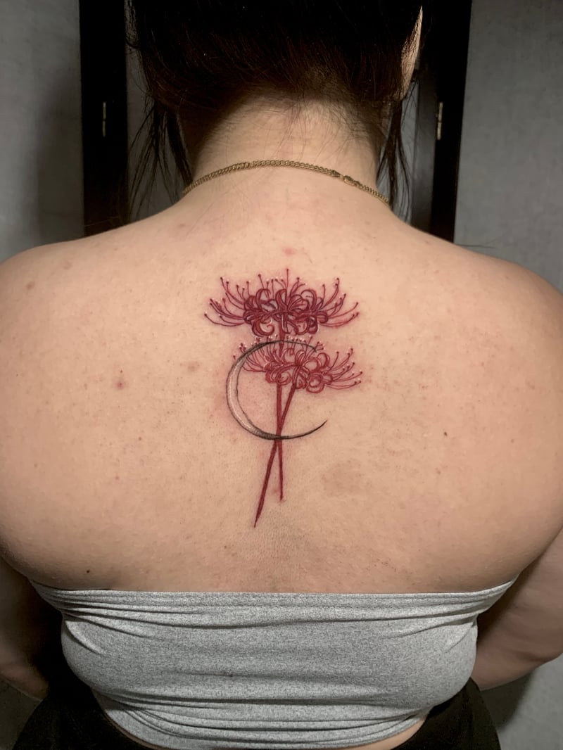 red-ink fine-line tattoo of spider lilies curling around a crescent moon by Shelby Bianco, a fine line tattoo artist in los angeles