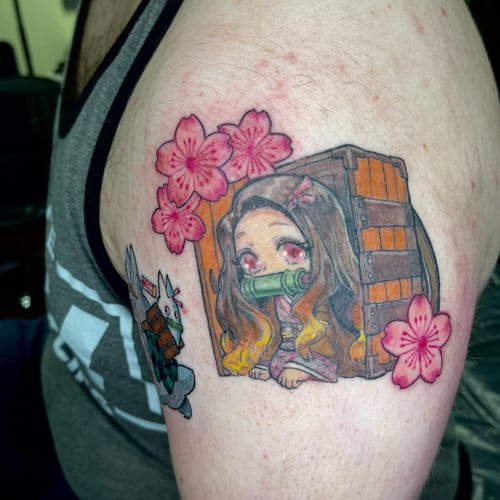 A colorful anime character tattoo on the upper arm, featuring pink flowers and vibrant details — by Sandra Price, los angeles