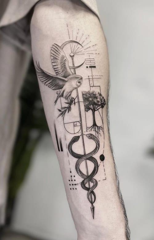 A black and grey tattoo on the forearm featuring a geometric design with a bird, tree, and snake intertwined with abstract elements — by Jian Liang, los angeles