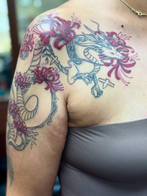 A colorful Japanese dragon with red flowers on the shoulder, featuring bold and ornate design elements — by Sandra Price, los angeles