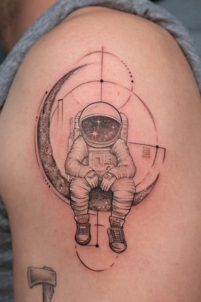 black & grey astronaut sitting on moon tattoo — by Vince Espinoza, los angeles
