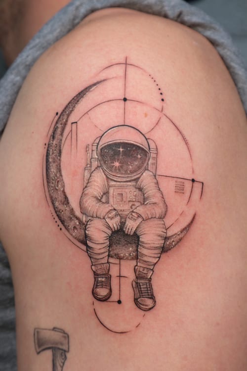black & grey astronaut sitting on moon tattoo — by Vince Espinoza, los angeles