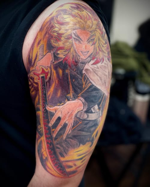 A bold and colorful anime character tattoo on the upper arm, featuring a character holding a sword with dynamic flames — by Sandra Price, los angeles