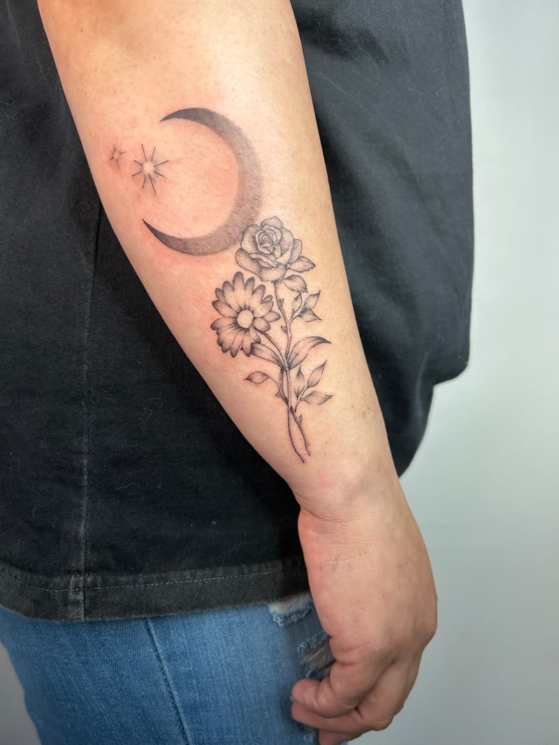 fine-line black and grey floral tattoo of a rose, daisy and sunflower under a crescent moon by Brian Kies, a fine line tattoo artist in highland park, los angeles