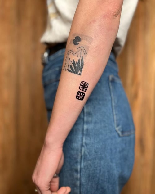 A minimalist black and grey abstract landscape tattoo on the forearm featuring geometric mountains and shapes — by Dylan Aiello, los angeles