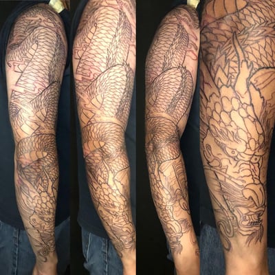 A bold black and grey Japanese dragon tattoo covering the full sleeve with intricate linework and detailed scales — by Sandra Price, los angeles