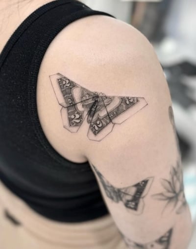 A black and grey realistic butterfly tattoo on the shoulder, featuring intricate details and shading — by otaybeatdown, los angeles