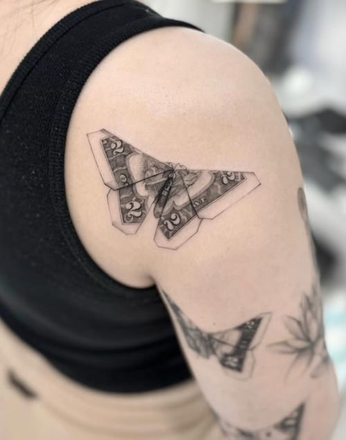 A black and grey realistic butterfly tattoo on the shoulder, featuring intricate details and shading — by otaybeatdown, los angeles