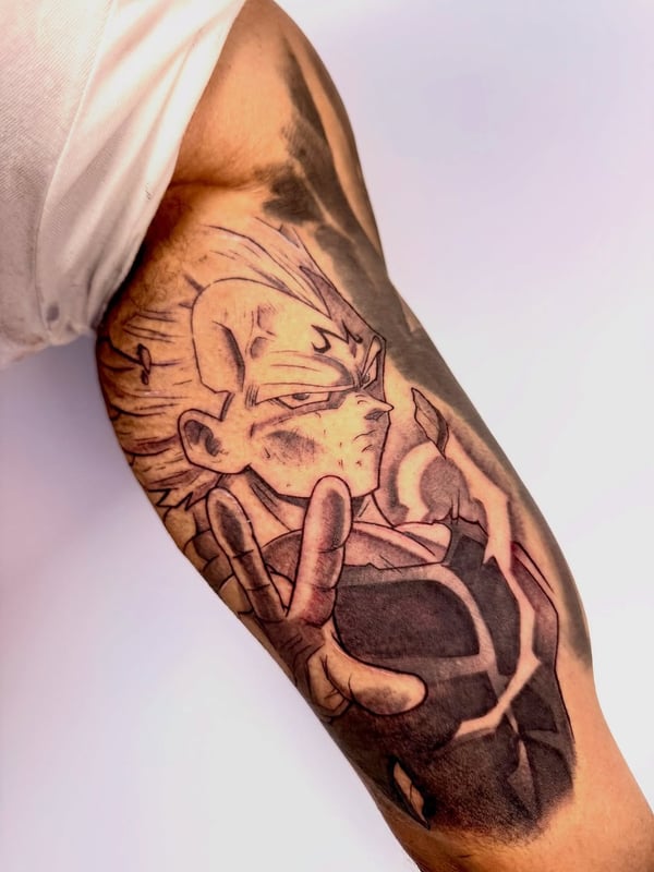 A bold black and grey anime character tattoo on the upper arm with strong graphic lines — by zealous, los angeles