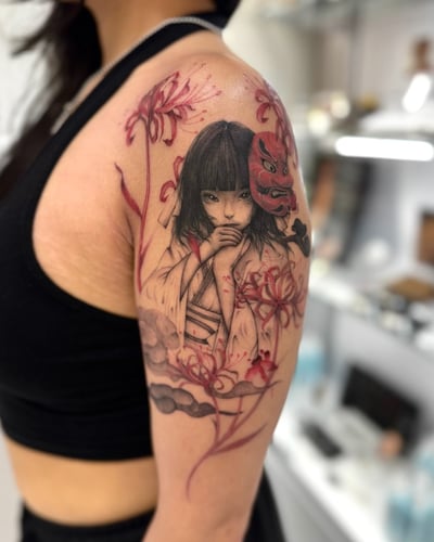 A Neo-Traditional Japanese style tattoo on the upper arm featuring a woman with a traditional mask and flowers, using a mixed color palette — by otaybeatdown, los angeles