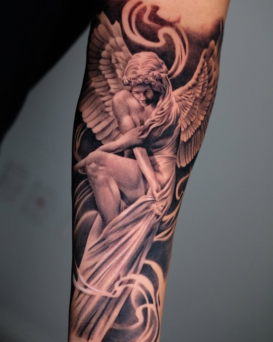 A realistic black and grey angel tattoo on the forearm, featuring detailed wings and a spiritual theme — by Johnny Ayala, los angeles