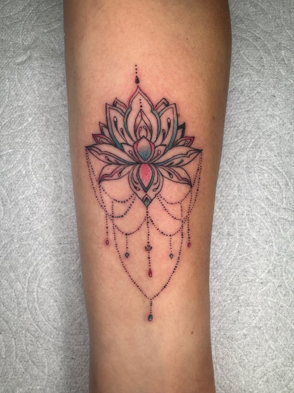 A delicate ornamental lotus flower tattoo on the forearm with dotwork details and subtle color accents — by Sandra Price, ventura, ca