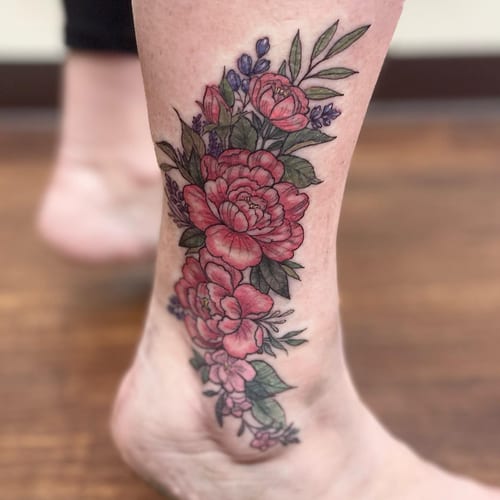 A colorful floral bouquet tattoo on the ankle featuring detailed flowers and leaves in a delicate style — by Sandra Price, los angeles