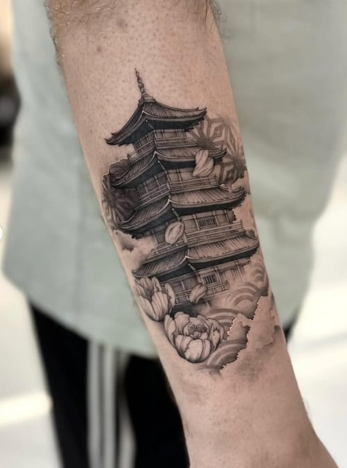 A detailed black and grey tattoo of a traditional Japanese pagoda on the forearm, surrounded by clouds and floral elements — by otaybeatdown, los angeles