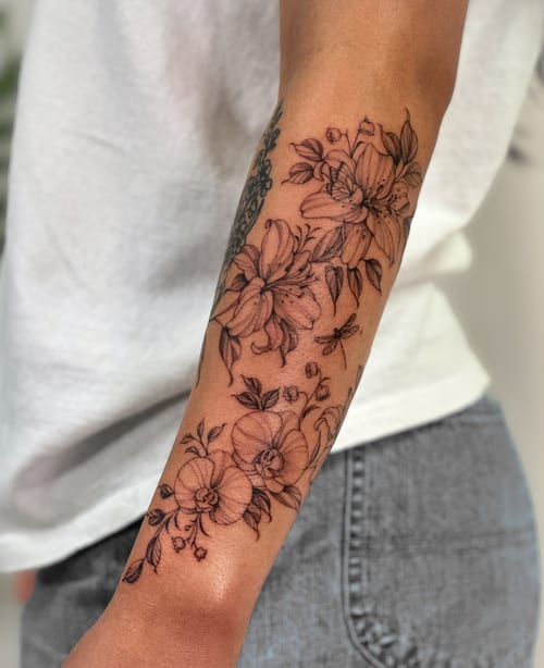 A delicate black and grey floral arrangement tattoo on the forearm, featuring fine line work and intricate details — by Melanie Benoit, los angeles