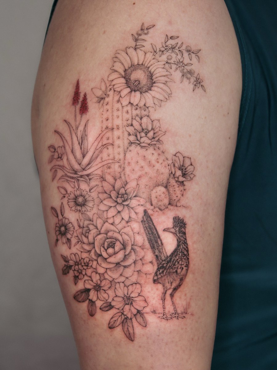 A delicate black and grey tattoo of a cactus and bird surrounded by flowers on the upper arm, featuring fine line and blackwork styles — by Melanie Benoit, los angeles