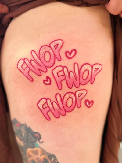 A colorful lettering tattoo on the thigh featuring the word 'FWOP' repeated three times with small hearts, in a bold, pop art style — by Tweetwee, los angeles