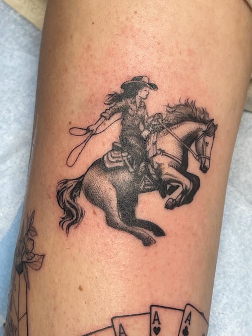 black & grey cowgirl on horseback tattoo — by Vince Espinoza, los angeles