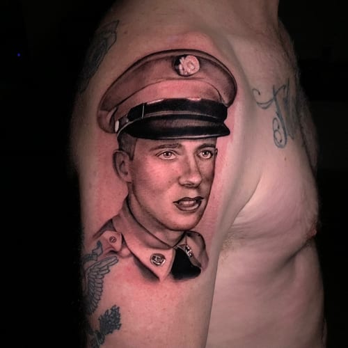 A black and grey realism portrait of a man in uniform on the upper arm, featuring detailed shading and lifelike features — by Travis Ross, los angeles