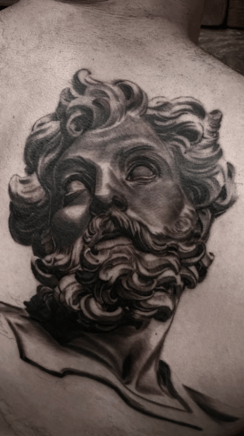A black and grey realism portrait of Zeus on the back, featuring detailed shading and intricate hair and beard — by tyler_whitlock, los angeles