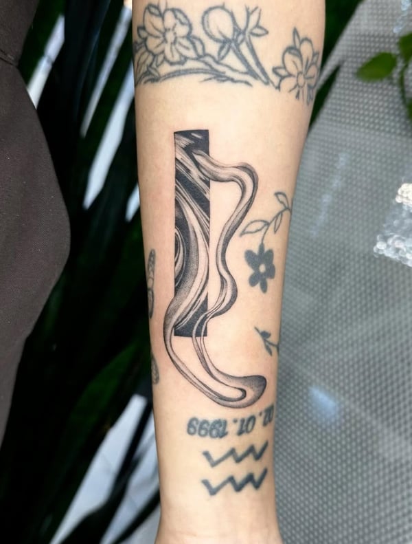An abstract blackwork tattoo on the forearm featuring flowing lines and shapes within a rectangular frame — by otaybeatdown, orange, ca