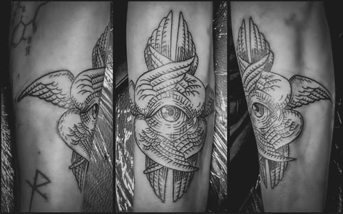 A black and grey linework tattoo on the forearm featuring an eye with wings, showcasing intricate line details and shading — by Tag Devilish, los angeles