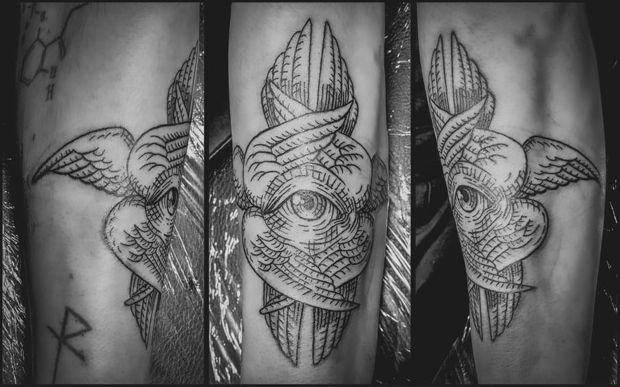 A black and grey linework tattoo on the forearm featuring an eye with wings, showcasing intricate line details and shading — by Tag Devilish, los angeles