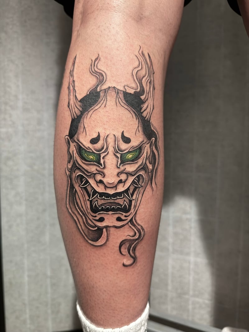 japanese hannya mask tattoo on the calf with bold black outlines and green eyes by Shelby Bianco, a japanese tattoo artist in los angeles