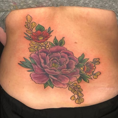 A colorful neo-traditional flower bouquet tattoo on the back, featuring bold and ornate floral designs — by Sandra Price, los angeles