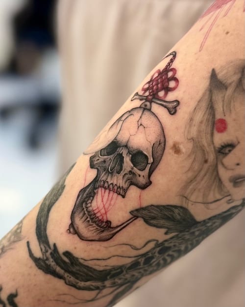 A mixed color tattoo featuring a skull with a snake, incorporating blackwork and illustrative styles on the arm — by otaybeatdown, los angeles
