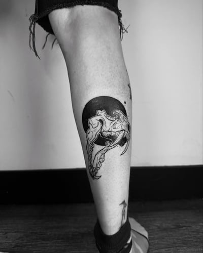 A black and grey skull with octopus tentacles tattoo on the calf, featuring a bold blackwork style — by zealous, los angeles