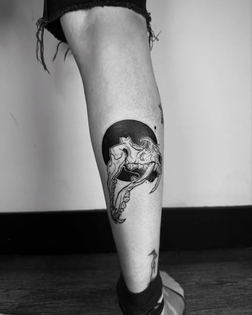A black and grey skull with octopus tentacles tattoo on the calf, featuring a bold blackwork style — by zealous, los angeles