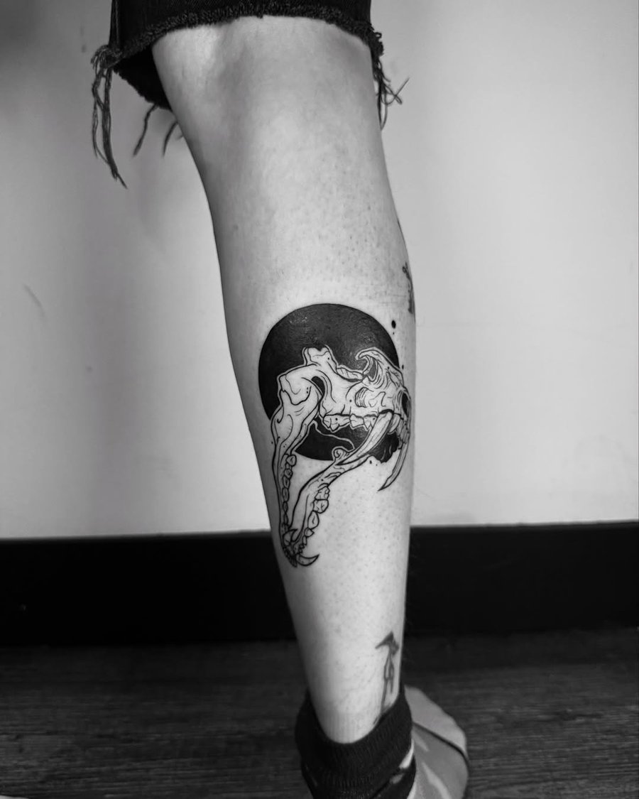A black and grey skull with octopus tentacles tattoo on the calf, featuring a bold blackwork style — by zealous, los angeles