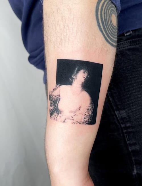 A black and grey surrealism portrait on the forearm, featuring a stylized depiction of a person with abstract elements — by Level tattoo, los angeles