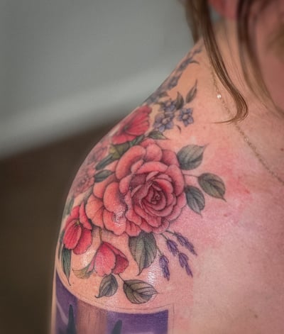 A colorful floral bouquet tattoo on the shoulder featuring realistic roses and delicate flowers — by Melanie Benoit, los angeles