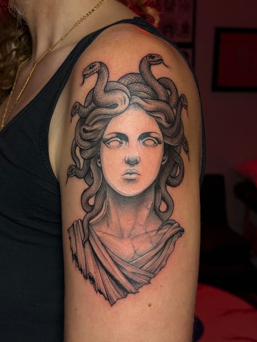 A black and grey neo-traditional tattoo of Medusa on the upper arm, featuring detailed snakes and classical styling — by Vince Espinoza, los angeles