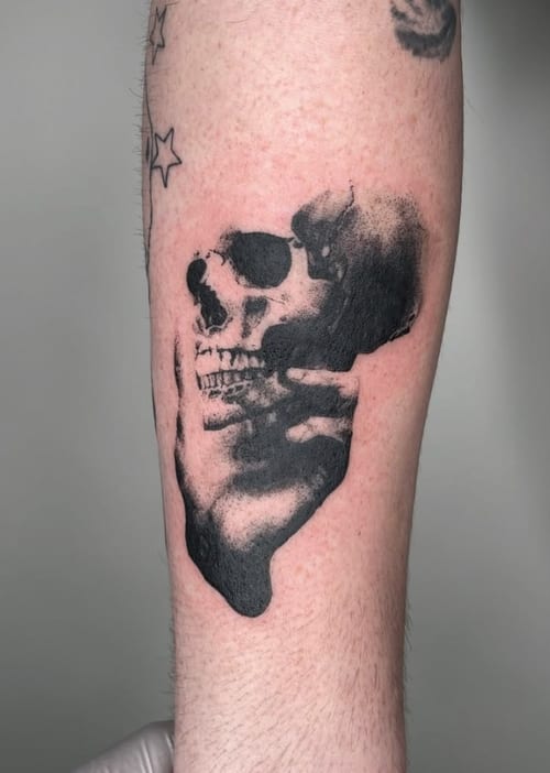 A black and grey abstract skull tattoo on the forearm with bold blackwork style and high contrast — by Level tattoo, los angeles