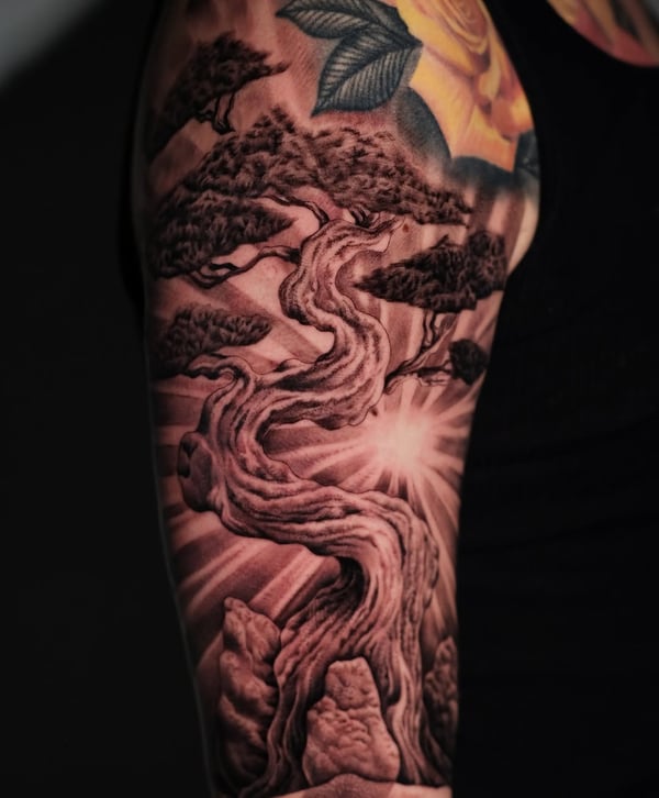 A detailed black and grey tattoo of a twisted tree on the upper arm with realistic shading and texture — by Johnny Ayala, fontana, ca