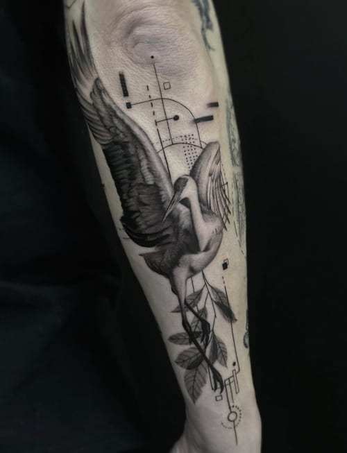 A black and grey realism tattoo of a bird in flight on the forearm, featuring geometric elements and detailed shading — by Jian Liang, los angeles
