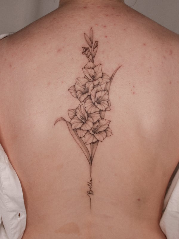 A delicate black and grey fine line tattoo of gladiolus flowers on the back, showcasing intricate floral details — by Melanie Benoit, los angeles