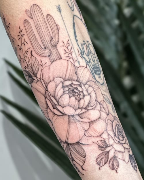 A delicate black and grey tattoo featuring a cactus, flowers, and a skull on the forearm — by Melanie Benoit, los angeles