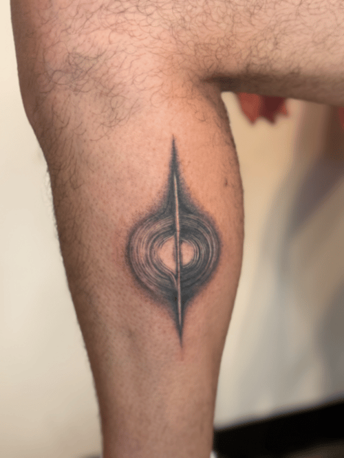 abstract blackwork of a vertical spike piercing concentric rings, dotwork shading on the calf — by Samantha Wilks, los angeles