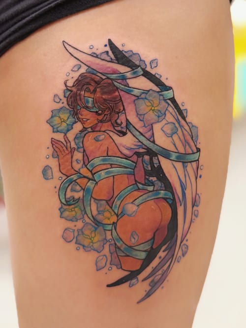 A colorful illustrative tattoo of a woman with wings surrounded by flowers on the thigh, featuring vibrant blue and yellow hues — by Tweetwee, los angeles