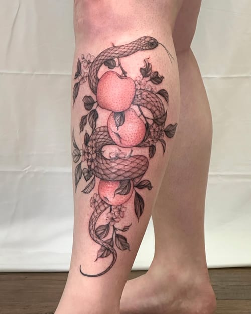 A graphic black and grey tattoo of a snake intertwined with apples and flowers on the leg, featuring an illustrative style with mixed color accents — by Melanie Benoit, los angeles
