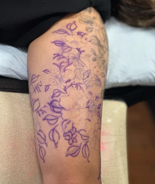 A delicate linework tattoo featuring flowers and a butterfly on the arm, showcasing intricate floral details — by Melanie Benoit, los angeles
