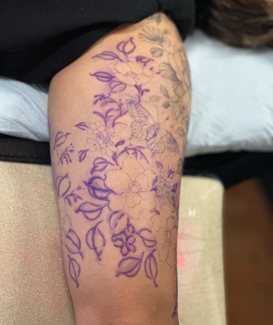 A delicate linework tattoo featuring flowers and a butterfly on the arm, showcasing intricate floral details — by Melanie Benoit, los angeles