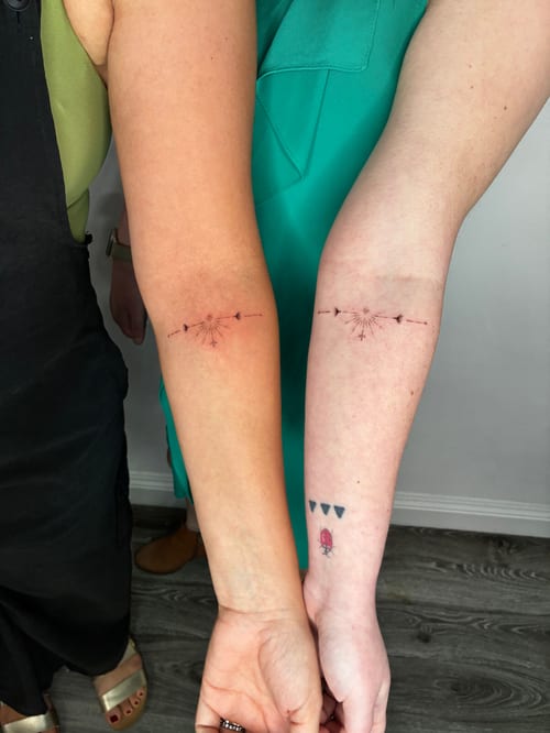 A minimalist fine line tattoo of an arrow on the forearm, featuring delicate lines and subtle color accents — by Edgar Armas Rodriguez, los angeles