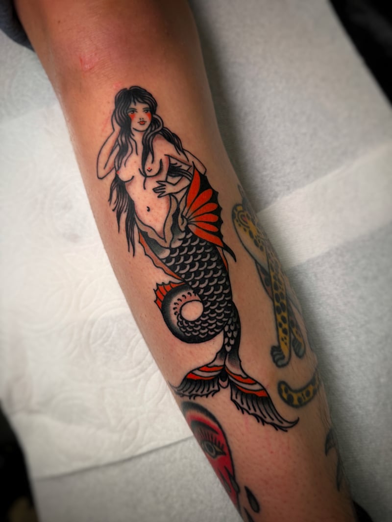 american traditional mermaid tattoo in black and red on the forearm by Josh Rosa, a traditional tattoo artist in highland park, los angeles